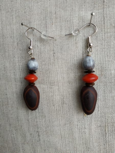 Boucles d'oreilles en gros plan sur fond gris. Chaque boucle possède une oreille à mulâtre, une monval, une larme de job et une l'église.