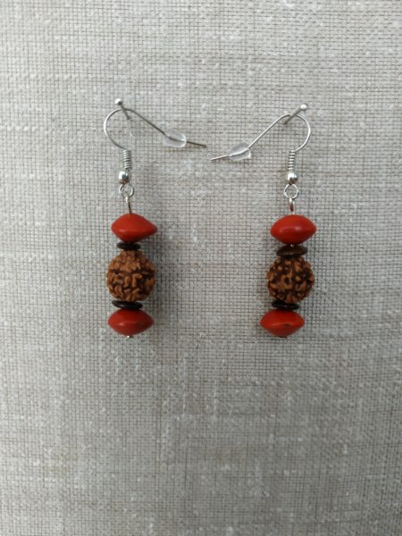 Boucles d'oreilles en gros plan sur fond gris. Chaque boucle contient une larmes de Shiva, deux monval et deux l'église.