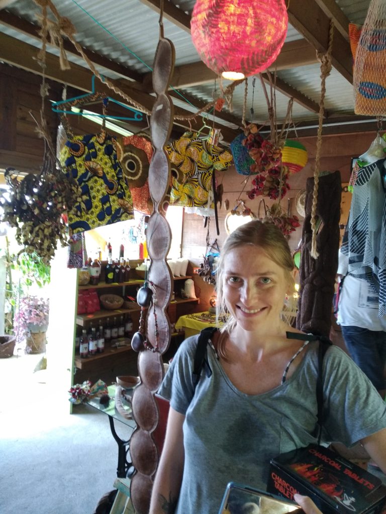 photo de la créatrice Stéphanie en Martinique avec dans le fond des gousses et graines des Antilles